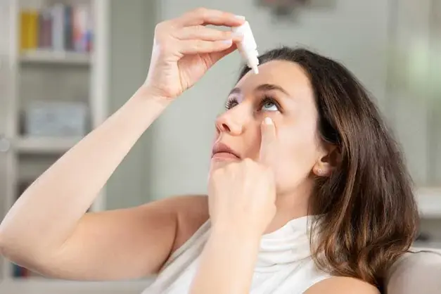 Woman applying eye drops for dry eye treatment