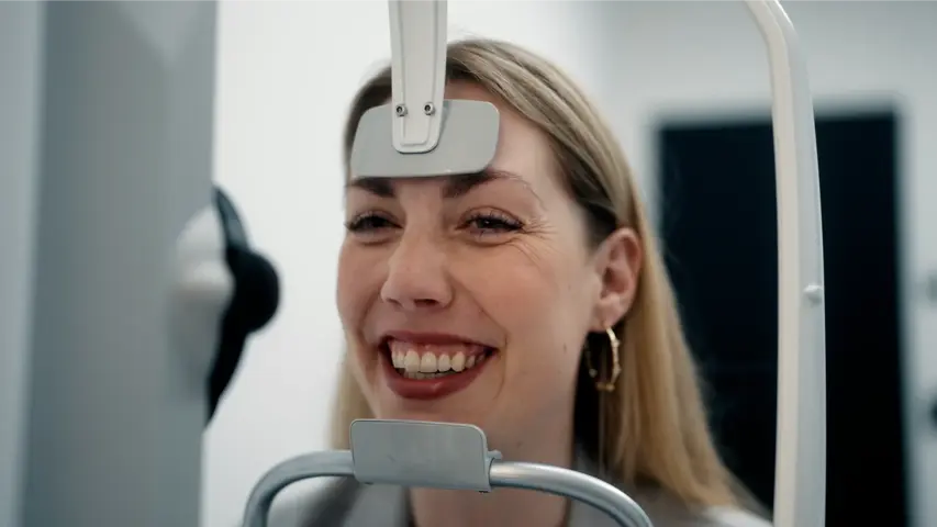  Patientin verabschiedet sich von ihrer Brille in der Hand