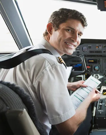 Ein Pilot im Cockpit mit einer Checkliste für das augenärztliche Gutachten